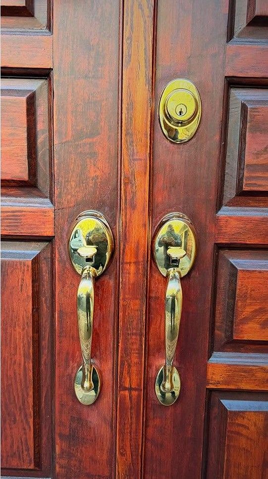Polished brass entry handleset and deadbolt on a residential front door